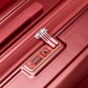TSA-accepted combination lock detail on red OIWAS CLAD suitcase—secure and travel-compliant.