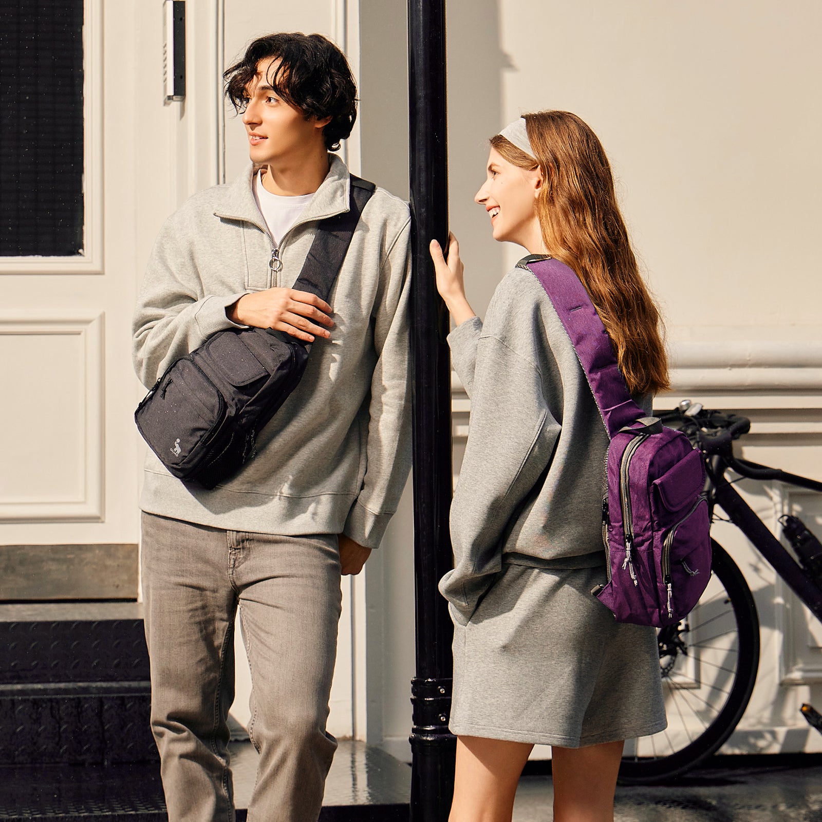 OIWAS purple sling bag worn crossbody by man & woman during urban commute